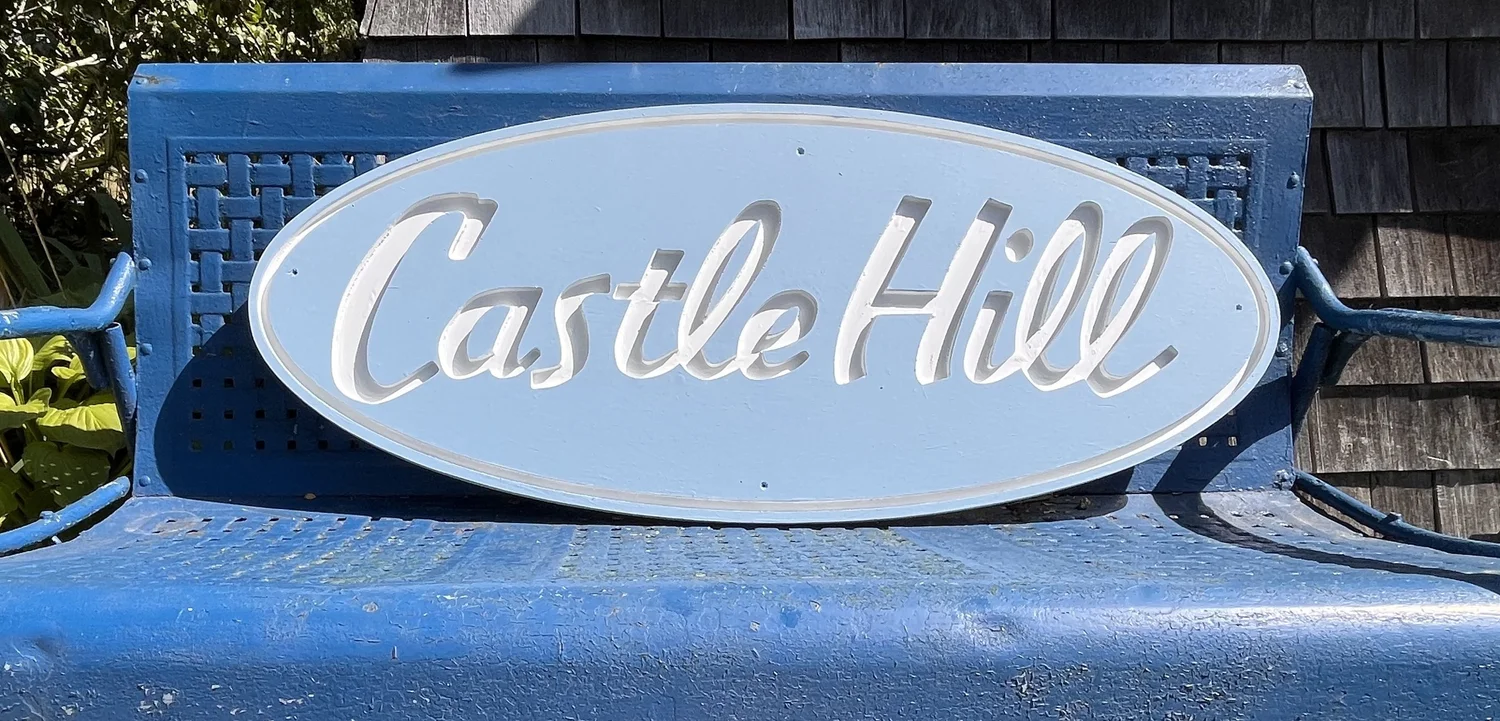 Castle Hill sign resting on a blue bench at Truro Center for the Arts