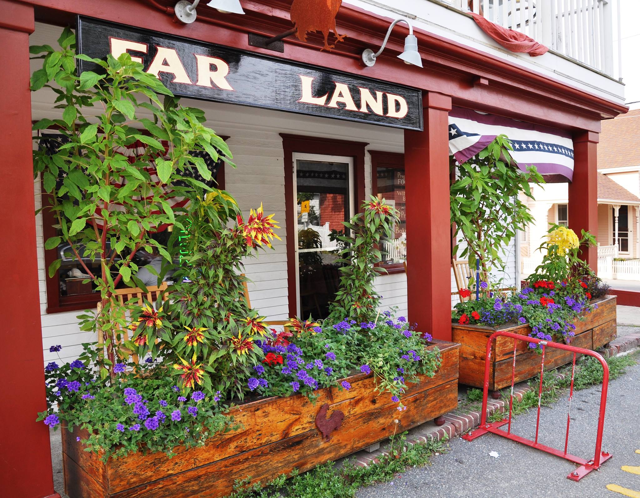 Far Land Provisions storefront on Bradford Street in Provincetown, with red trim and flower boxes