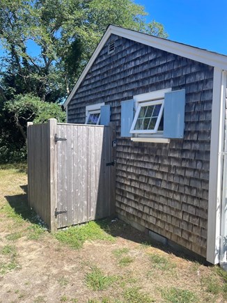 Enclosed outdoor shower beside a Shore Road cottage