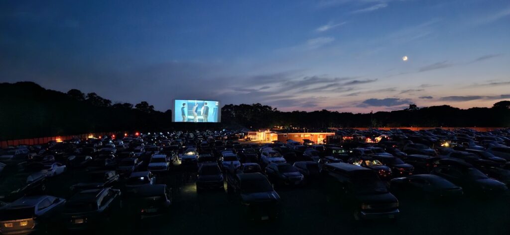 Cars facing the outdoor screen at Wellfleet Drive-In at dusk